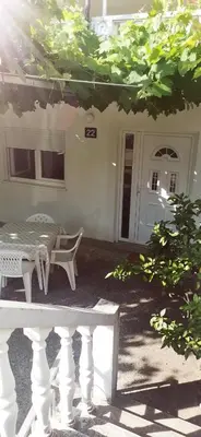 a white table and chairs in front of a house at Sobe i apartmani Marović in Petrovac na Moru