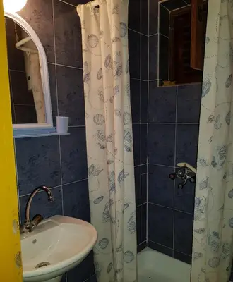 a bathroom with a sink and a shower curtain at Sobe i apartmani Marović in Petrovac na Moru
