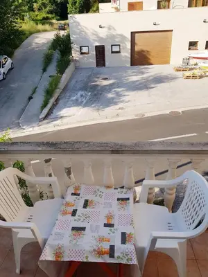 a table with a quilt on it on a balcony at Sobe i apartmani Marović in Petrovac na Moru