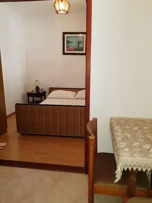 a bedroom with a bed and a table and a chair at Sobe i apartmani Marović in Petrovac na Moru