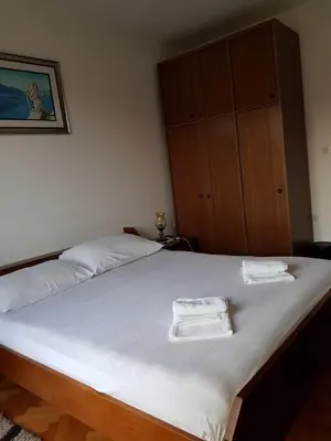 a bedroom with a large bed with two towels on it at Sobe i apartmani Marović in Petrovac na Moru