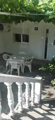 a table and a bench in front of a house at Sobe i apartmani Marović in Petrovac na Moru