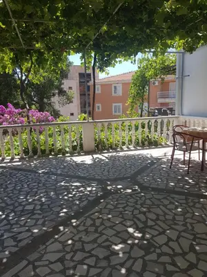 a patio with a table and chairs and a fence at Sobe i apartmani Marović in Petrovac na Moru