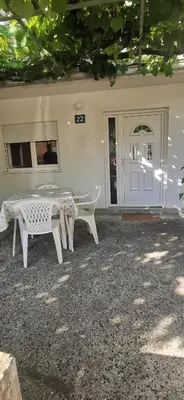 a white table and chairs in front of a house at Sobe i apartmani Marović in Petrovac na Moru