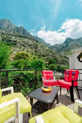 a balcony with colorful chairs and a table with a view at Spacious Central Magik in Kotor