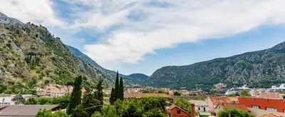 a town in front of mountains with buildings and trees at Spacious Central Magik in Kotor