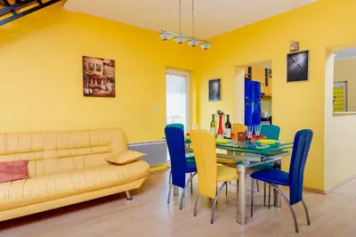 a dining room with a table and chairs and a couch at Spacious Central Magik in Kotor