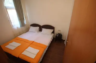 a bedroom with a bed with an orange blanket at Apartments Olga in Virpazar