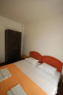 a bedroom with a large bed and a black cabinet at Apartments Olga in Virpazar