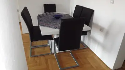 a dining room table with black chairs and a table and a table and chairsktop at Apartments Pines in Bar