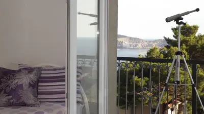 a balcony with a view of the ocean and a telescope at Apartments Pines in Bar