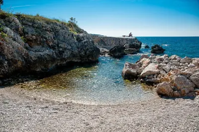a rocky shoreline with rocks and the ocean at Open Sea Apartments in Utjeha