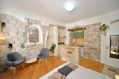 a living room with two chairs and a stone wall at Charming apartment in Kotor in Kotor