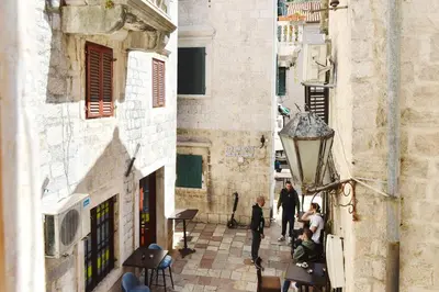 two people walking down a street in an alley at Charming apartment in Kotor in Kotor