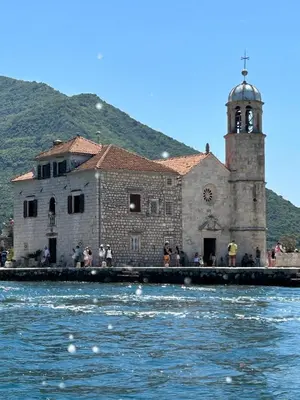 an old building with a clock tower next to the water at Charming apartment in Kotor in Kotor