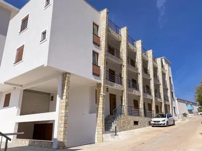 a white building with a car parked in front at Arabela 2 Apartments in Utjeha