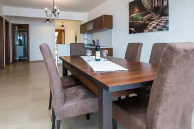 a dining room with a wooden table and chairs at Arabela 2 Apartments in Utjeha