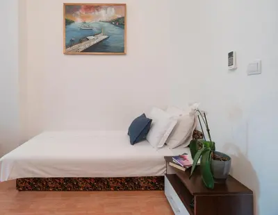 a bedroom with a bed with a picture on the wall at Mediterranean Guest House Balkan in Budva