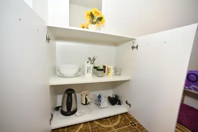 a kitchen with white walls and white shelves at MG apartments and rooms in Budva