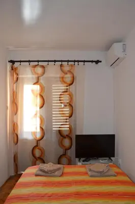 a bedroom with a bed and a television at MG apartments and rooms in Budva