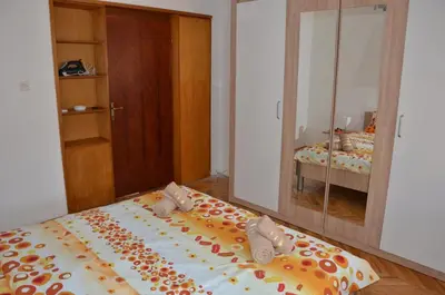 a bedroom with a large bed with shoes on it at MG apartments and rooms in Budva