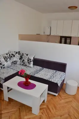 a living room with a bed and a table at MG apartments and rooms in Budva