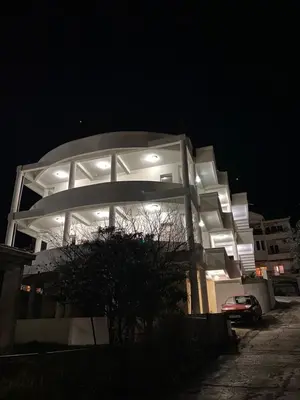 a large building with lights on it at night at Dajkovic Apartmani in Bar