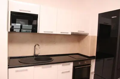 a kitchen with a sink and a black refrigerator at Apartment Obradovic in Budva