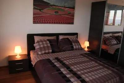 a bedroom with a bed with pillows and two lamps at Apartment Obradovic in Budva