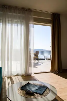 a living room with a glass table and a large window at Apartment Stojanovic in Bar