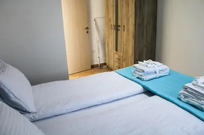 two beds in a room with towels on them at Apartment Stojanovic in Bar