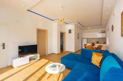 a living room with a blue couch and a tv at Apartment Stojanovic in Bar