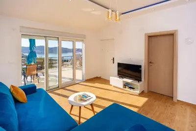 a living room with a blue couch and a tv at Apartment Stojanovic in Bar