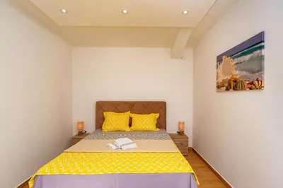 a bedroom with a large bed with yellow pillows at Apartment Stojanovic in Bar