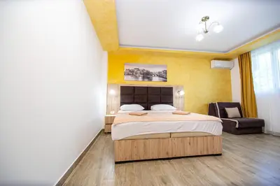 a bedroom with a large bed and a chair at Apartment Sofija in Budva