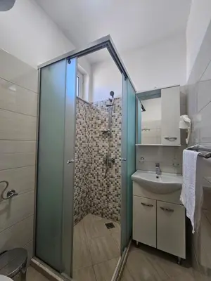 a bathroom with a glass shower and a sink at Casa ROBI - Apartments in Ulcinj