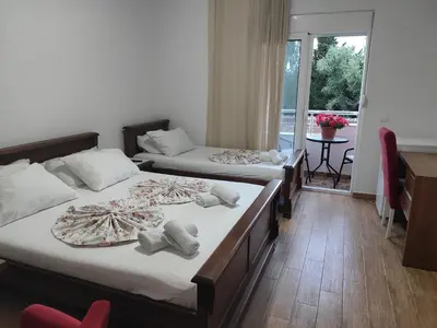 a bedroom with two beds and a desk and a window at Casa ROBI - Apartments in Ulcinj