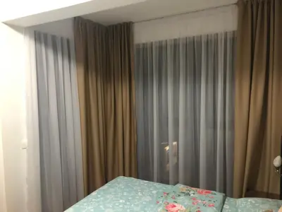 a bedroom with a bed and a window with curtains at Apartment Veselin in Budva