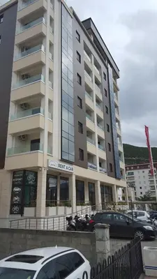 a large building with cars parked in front of it at Apartment Veselin in Budva
