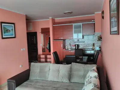 a living room with a white couch and a kitchen at Apartment Sea Space in Dobra Voda