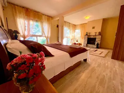 a bedroom with a large bed and a fireplace at Holiday Home Viko in Sutomore