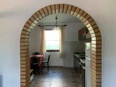 an archway in a kitchen with a table and a kitchen at Holiday Home Bratica in Ulcinj