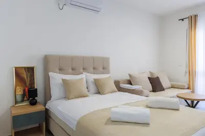 a bedroom with a large bed and a couch at Apartments Donna in Bar
