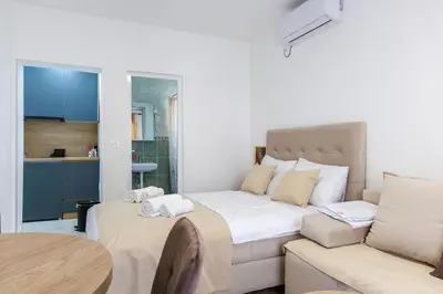 a bedroom with a bed and a couch and a table at Apartments Donna in Bar
