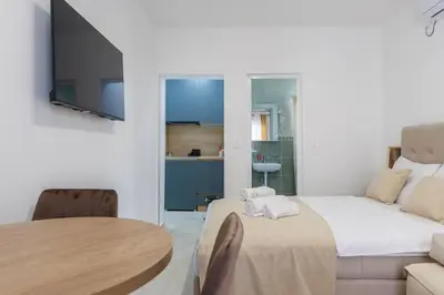 a room with a bed and a table and a tv at Apartments Donna in Bar
