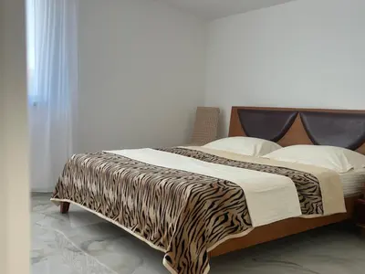 a bed with a zebra print blanket on it at Apartment Light House in Dobra Voda