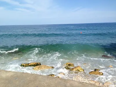 a body of water with rocks in the water at Apartment Light House in Dobra Voda