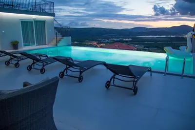 a swimming pool with chairs on the roof of a house at Apartment Kascelan in Kotor