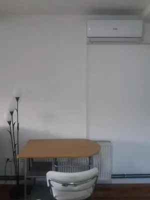 a table and a chair next to a table and a radiator at Apartments Mirković in Cetinje