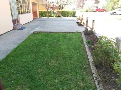 a yard of grass next to a driveway at Apartments Mirković in Cetinje